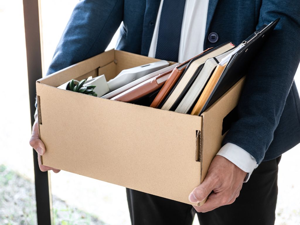 a person in a suit holding a box full of books